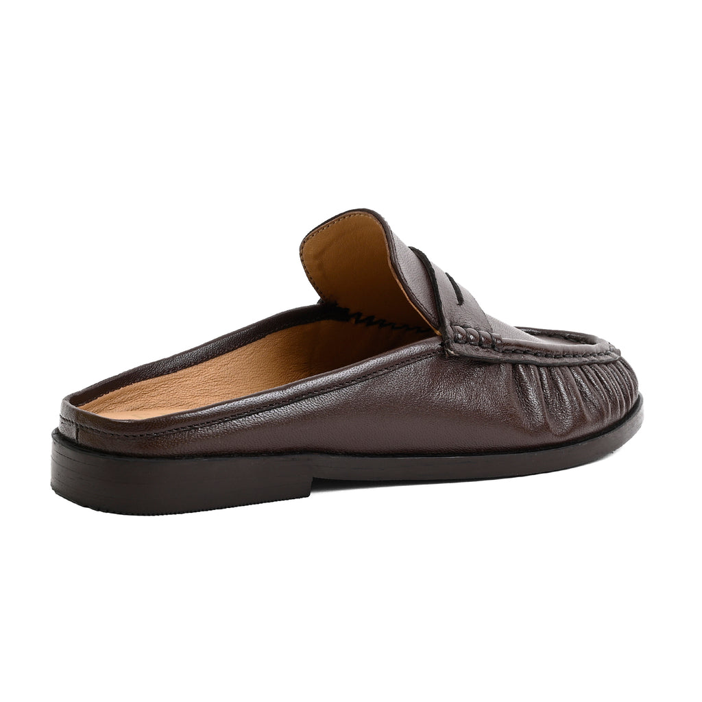 A dark brown leather slip-on loafer mule with a stitched detail across the vamp and a low black sole, shown from a side profile on a white background.