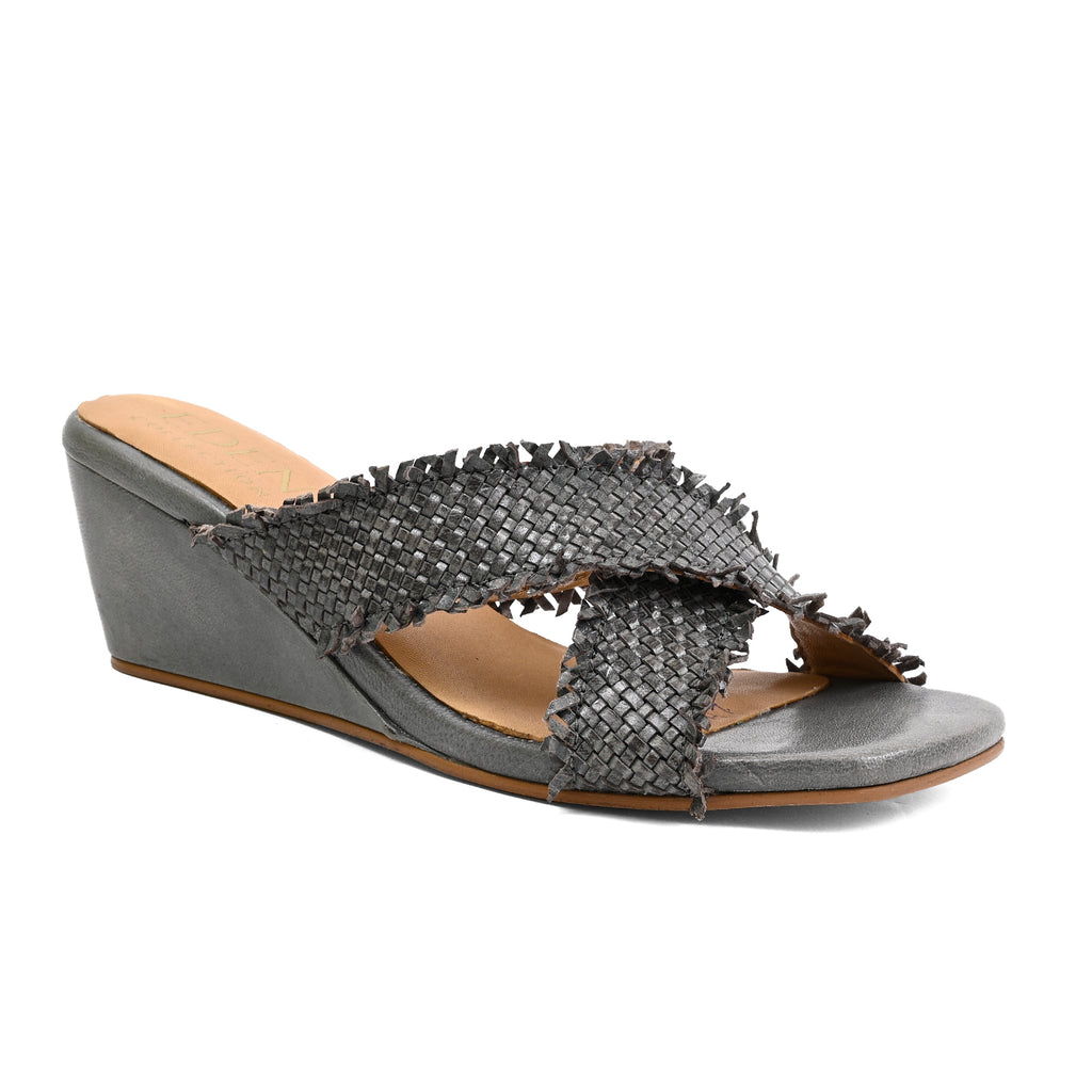 A single women's wedge slide sandal with a textured, woven-look upper in dark gray with frayed fringe details, set against a plain white background.
