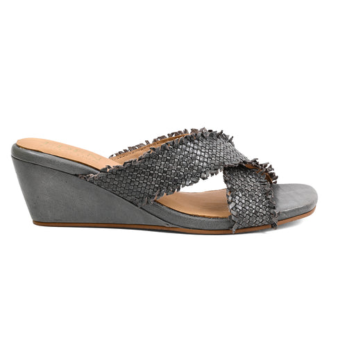 A single women's wedge slide sandal in gray, featuring a textured woven upper strap with frayed fringe details and a wedge heel, shown from a side profile on a white background.