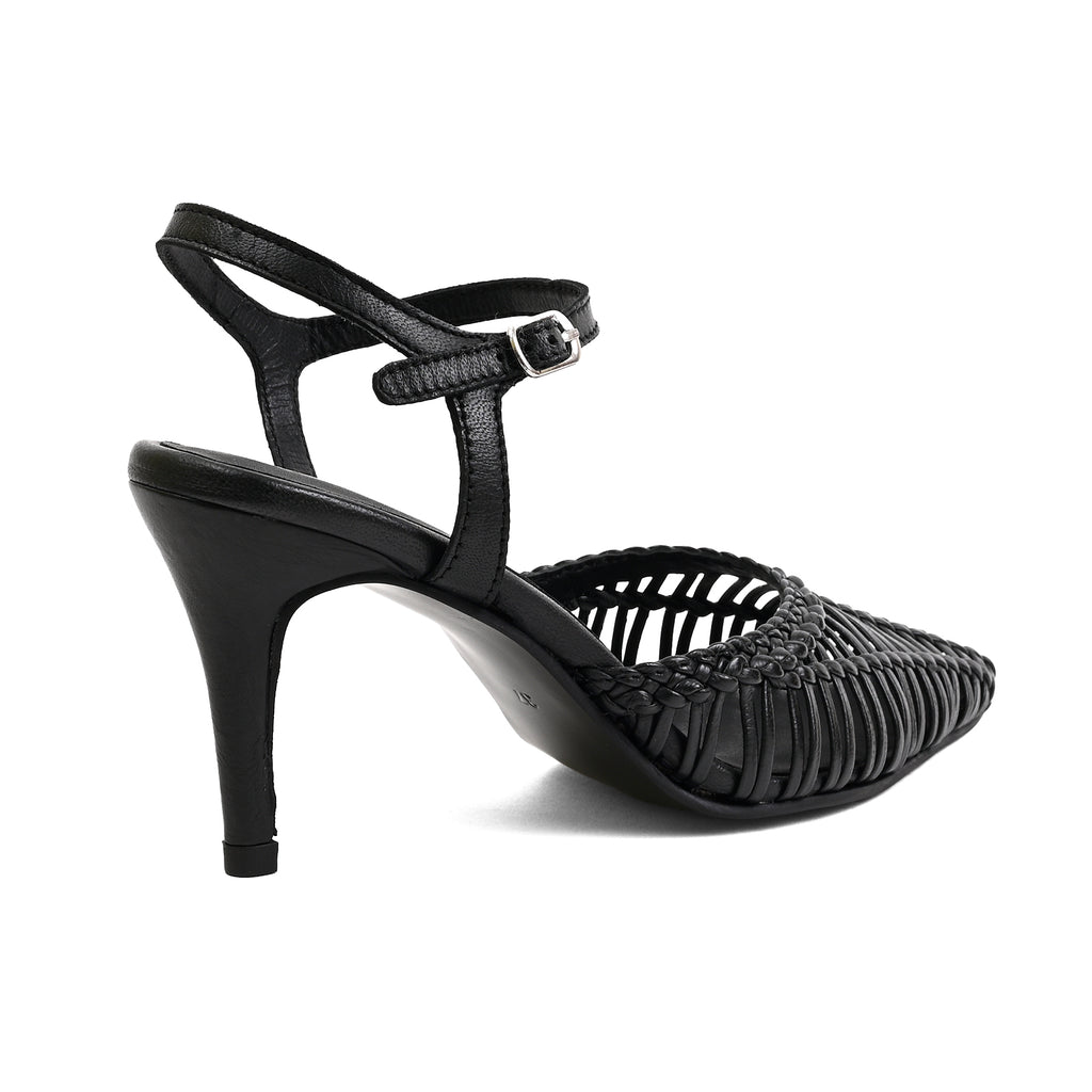 A black high-heeled sandal with a pointed toe, woven slatted upper, and adjustable ankle strap with a silver buckle, shown from a side-rear angle on a white background.